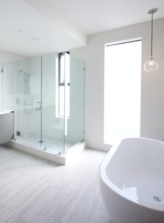 Modern domestic bathroom with shower cabin and freestanding bath, sunlight, no people